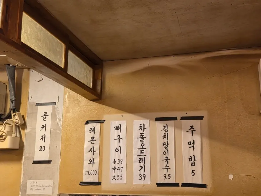 Side menu board listing rice balls, noodles, and potato pancake