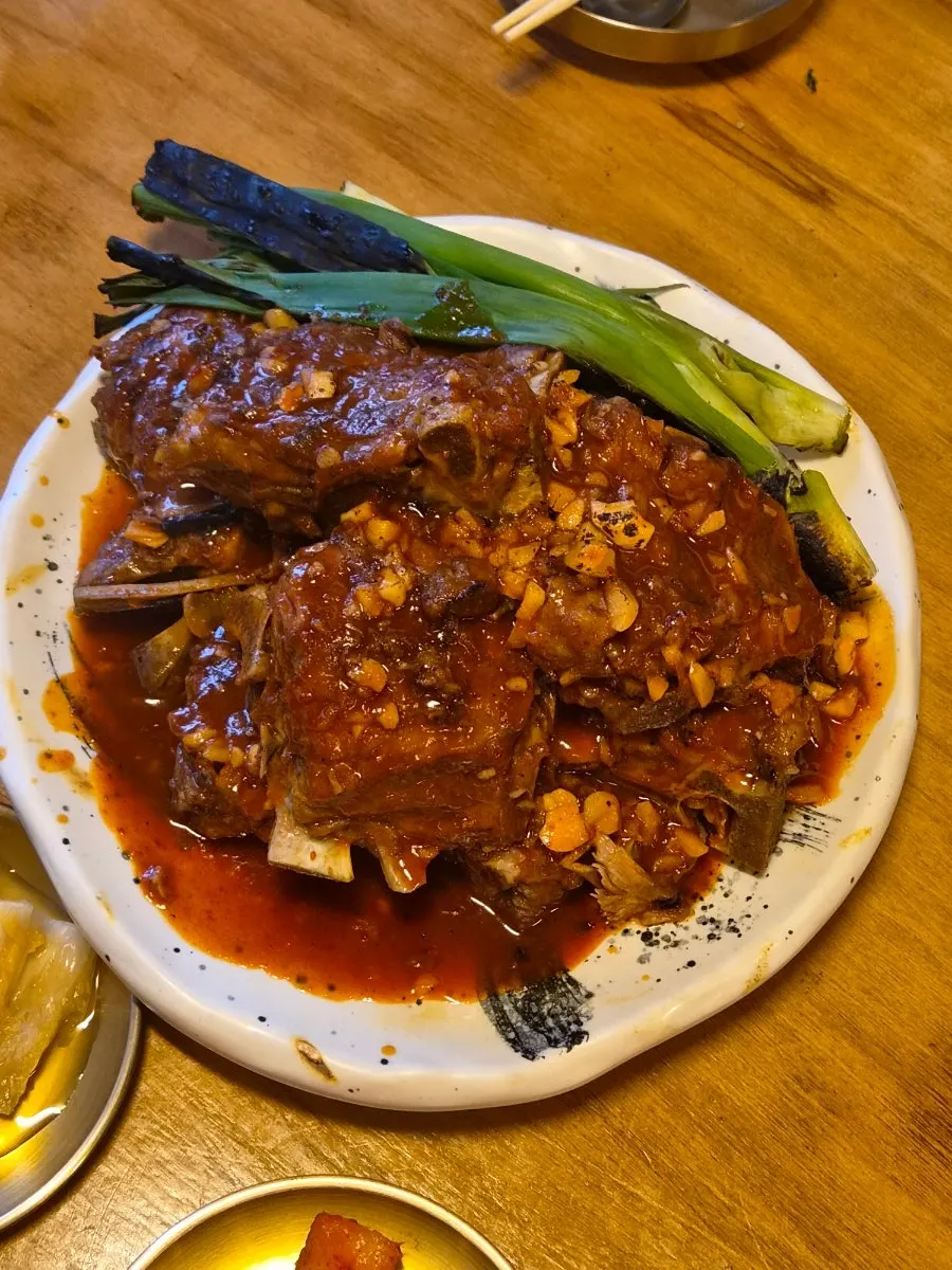 Medium charcoal bone BBQ topped with red sauce and grilled scallions