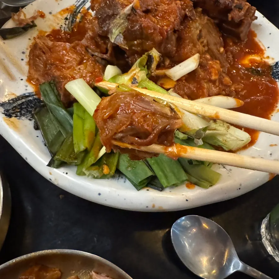 Tender meat pulled from grilled bones with grilled scallions