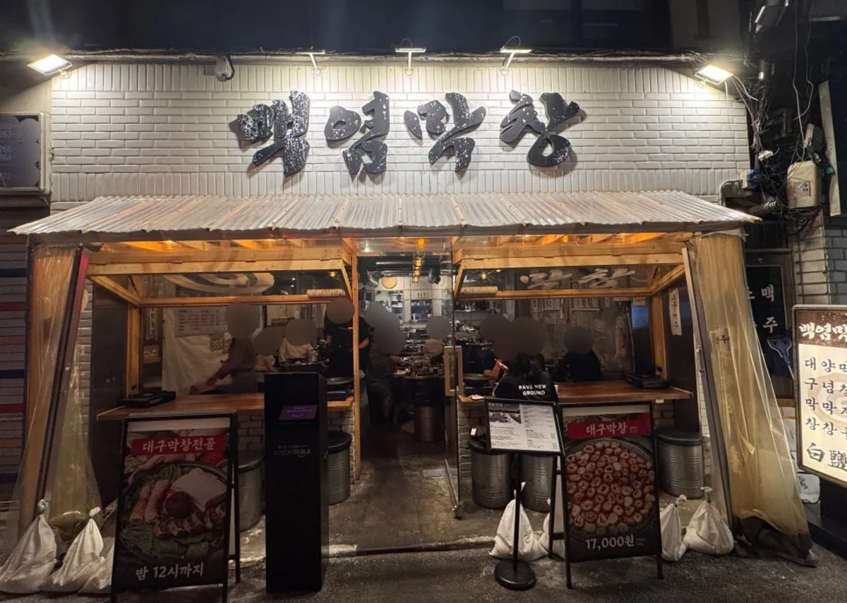 흰 타일 벽면에 검은 글씨 간판이 걸린 백염막창 을지로본점 외관