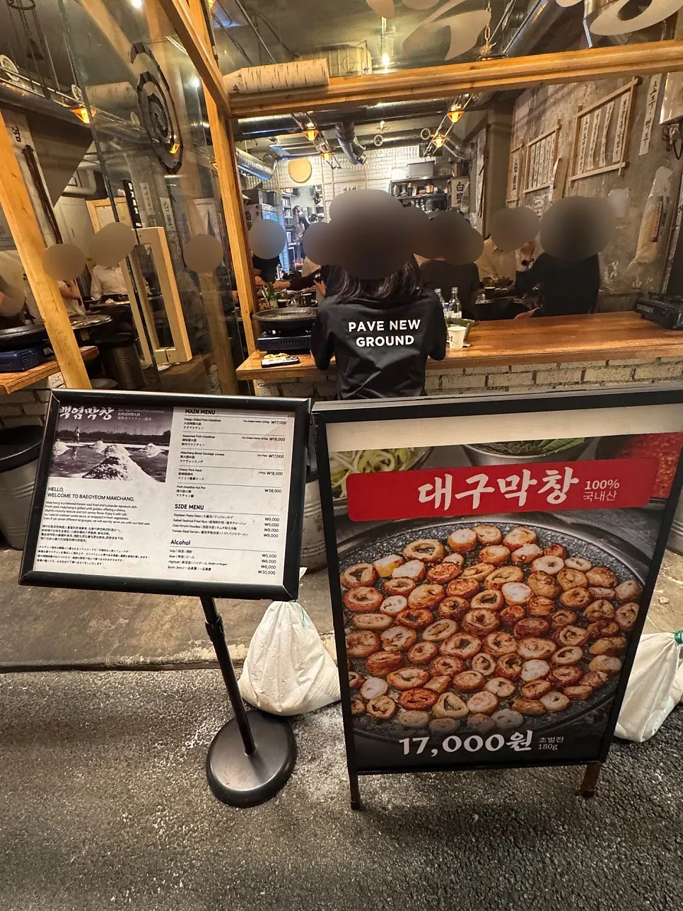 비닐 천막과 나무 테이블로 꾸민 창가 포장마차 자리