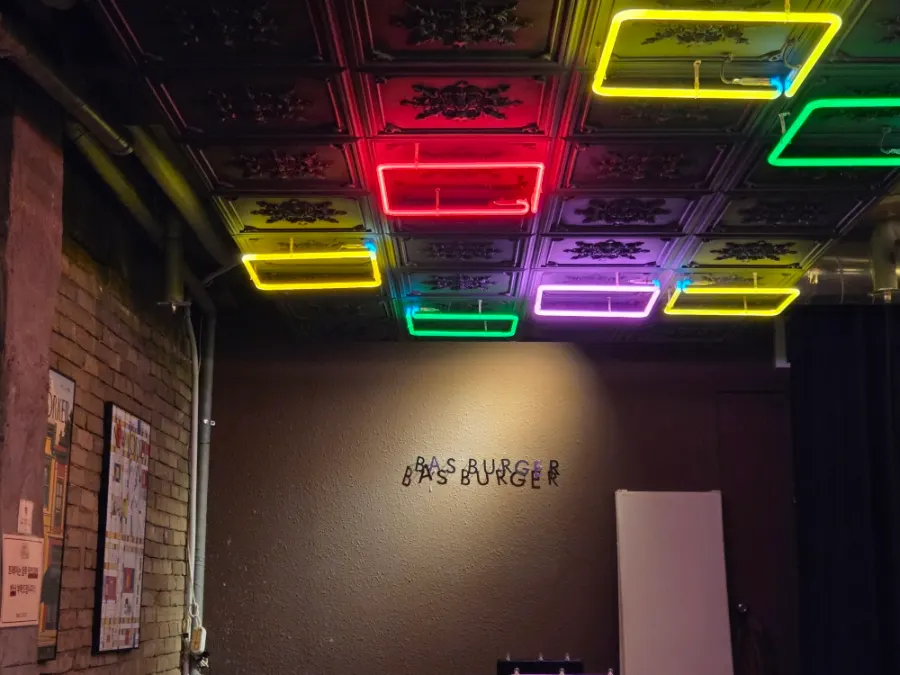 Interior of BAS Burger with high tables and soft lighting