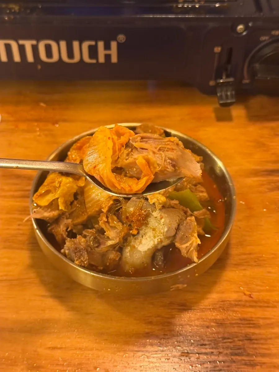 Tender meat separated from the bone alongside cabbage