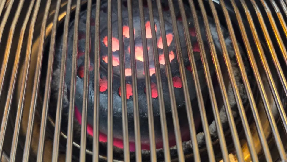 Pork slowly grilling over charcoal