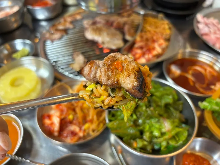 비빔밥 위에 구운 고기를 올린 한 숟갈