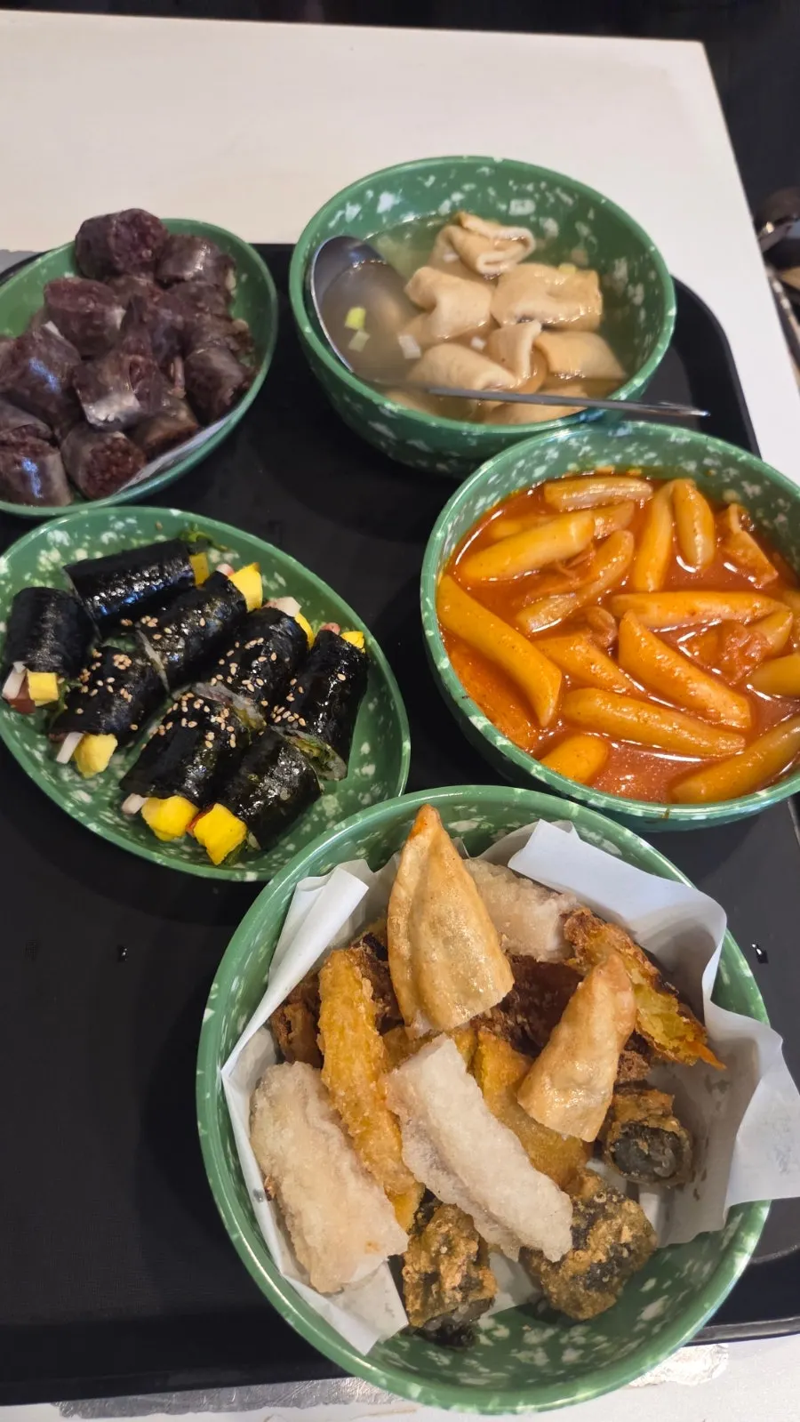 테이블에 늘어놓은 떡볶이 튀김 김밥 순대 어묵
