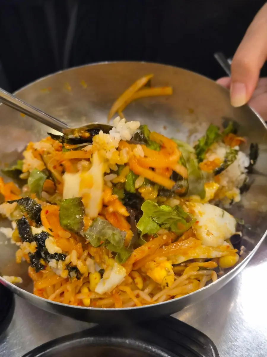 A spoonful of samsuni bibimbap eaten with the meat