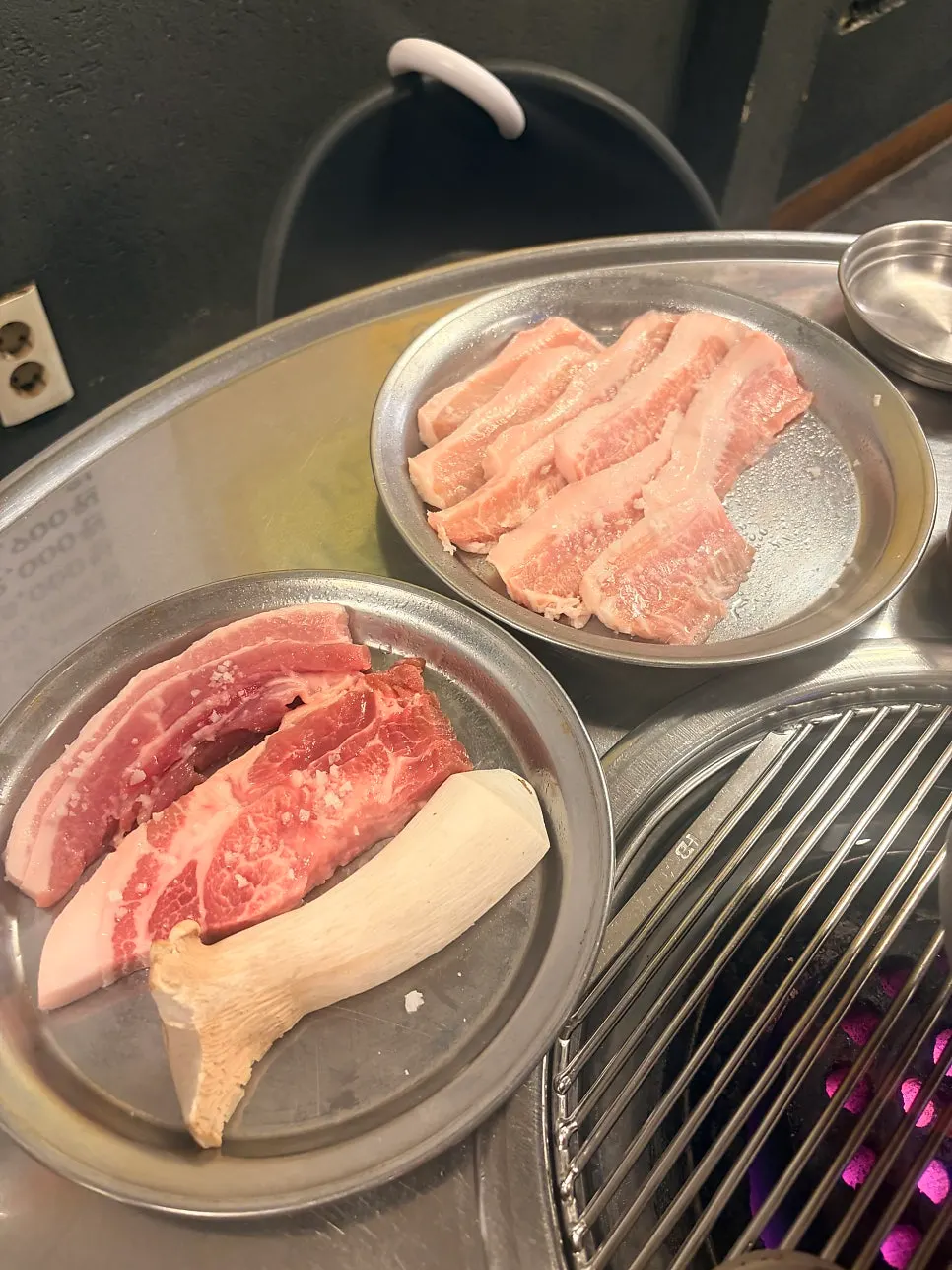 Thick pork belly grilling over charcoal