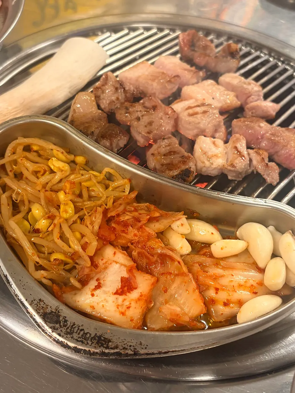 Kimchi and bean sprouts grilling in the steel side tray