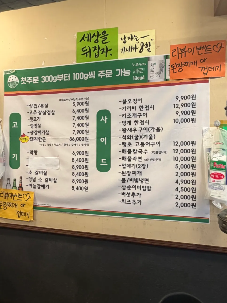 원형 테이블에 세팅된 연탄 불판과 기본 세팅