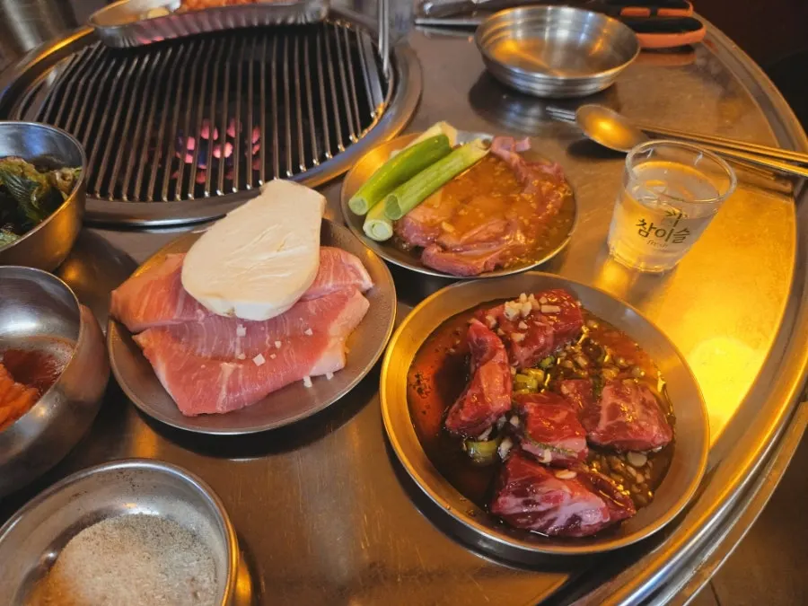 Three plates of seasoned beef flap steak, pork jowl, and garlic skirt steak