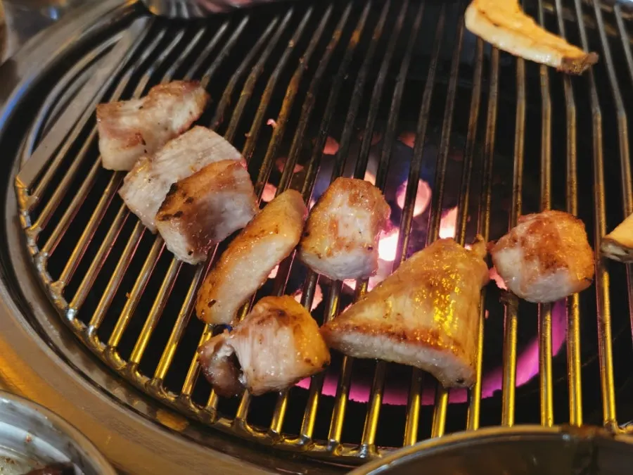 Cooked meat pushed to the side of the grill