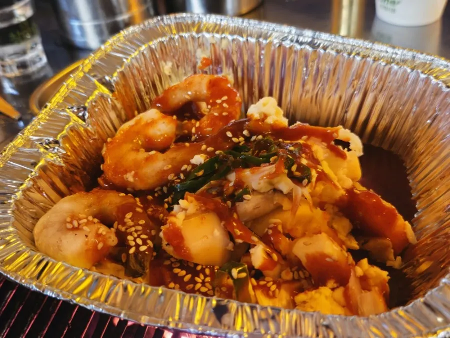 A large pen shell clam grill topped with shrimp and mushrooms