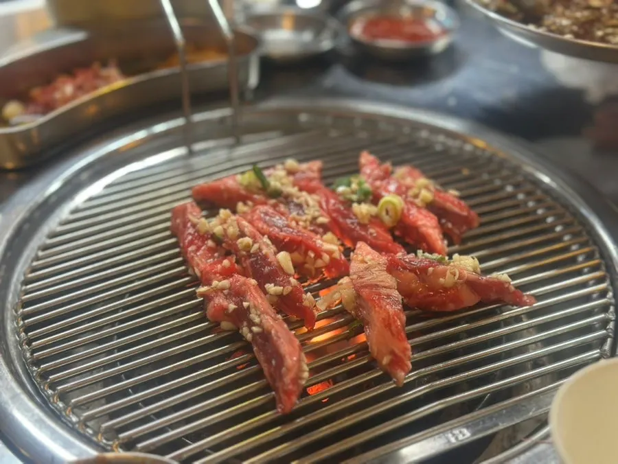 연탄불에 익어가는 양념 소갈빗살과 구운 마늘