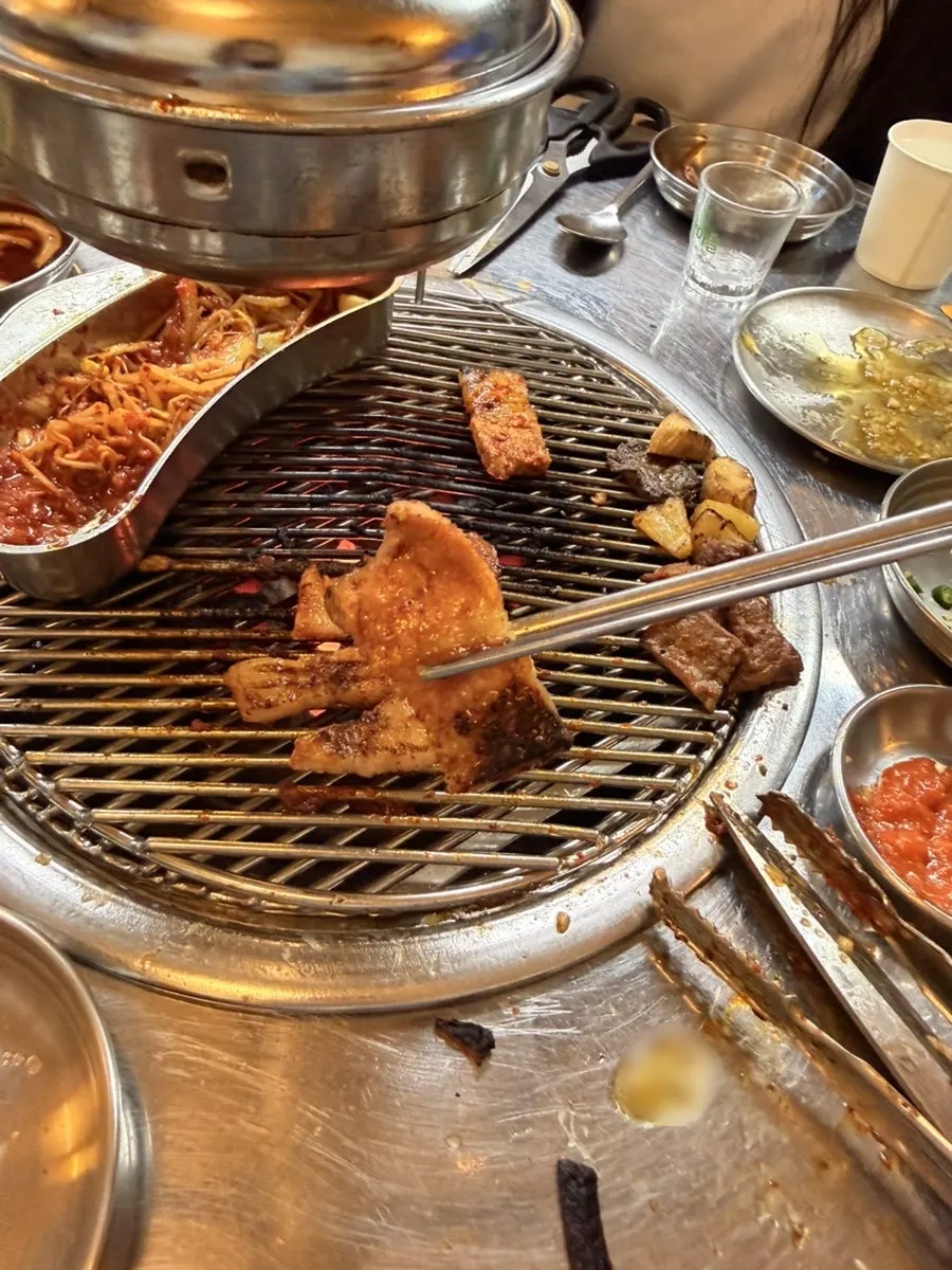 Gochujang pork belly slowly cooking on the charcoal grill