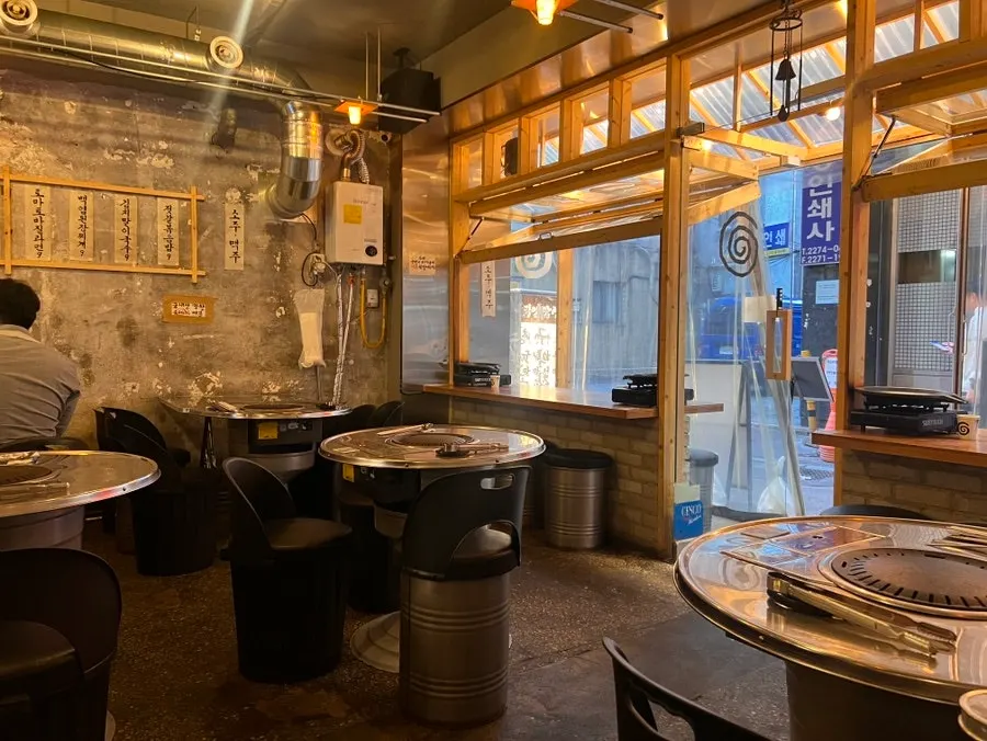 Seating area with one side open to windows at Baegyeom Makchang