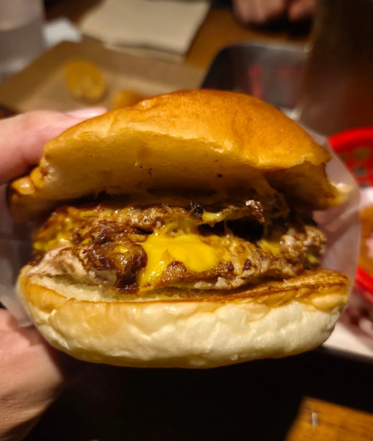 BAS Burger Double Bacon Cheeseburger held in one hand