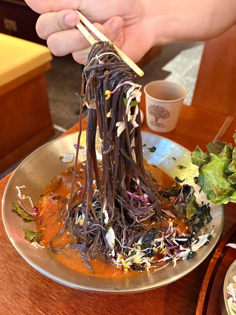 Cold buckwheat noodles topped with baby greens and shredded seaweed