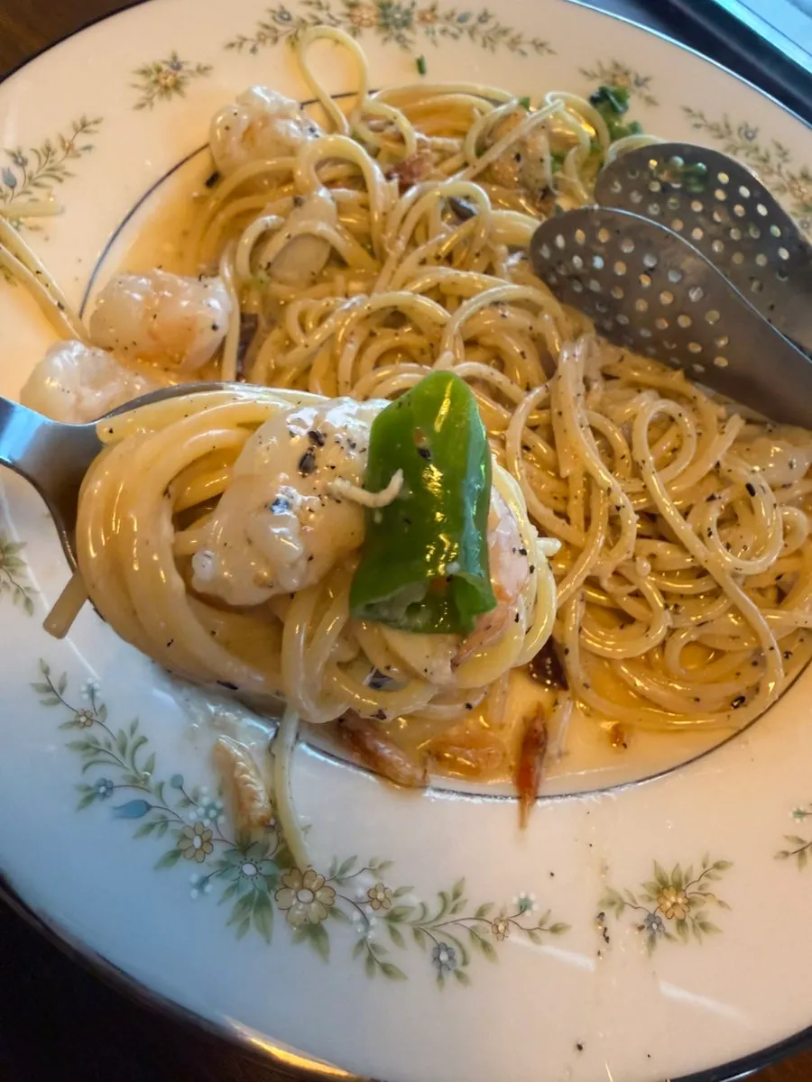 A forkful of niboshi shrimp oil pasta lifted up