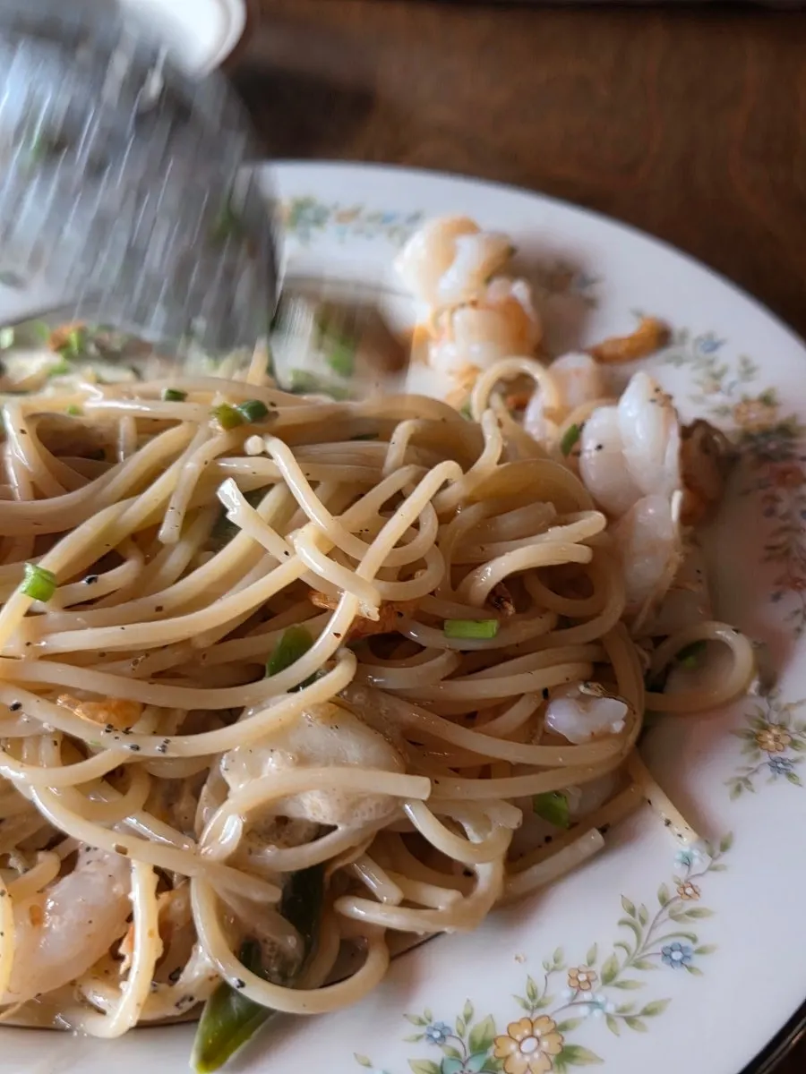 Nearly empty plate of niboshi shrimp oil pasta