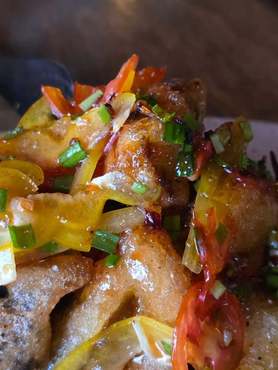 Close-up of crispy eoxianggaji topped with sauce