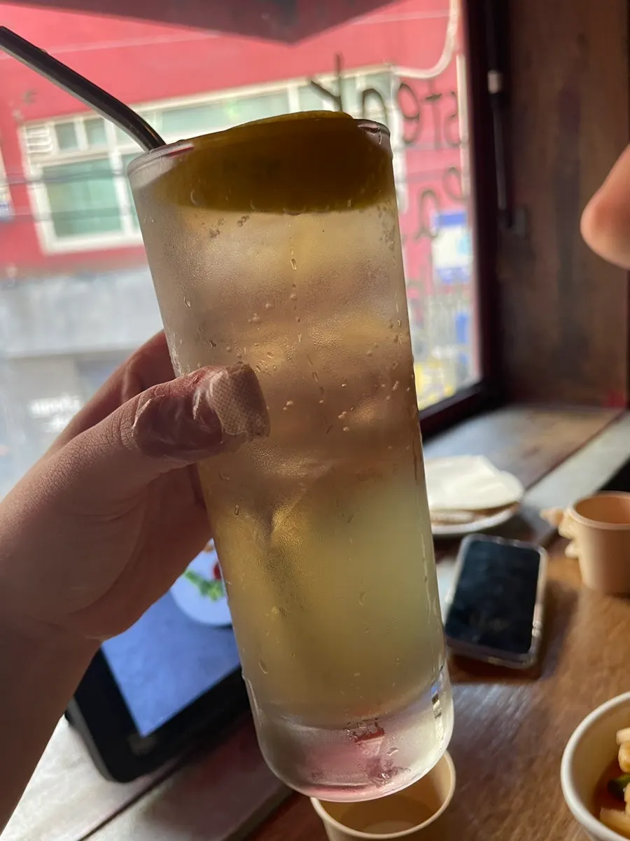 A highball glass next to the pasta