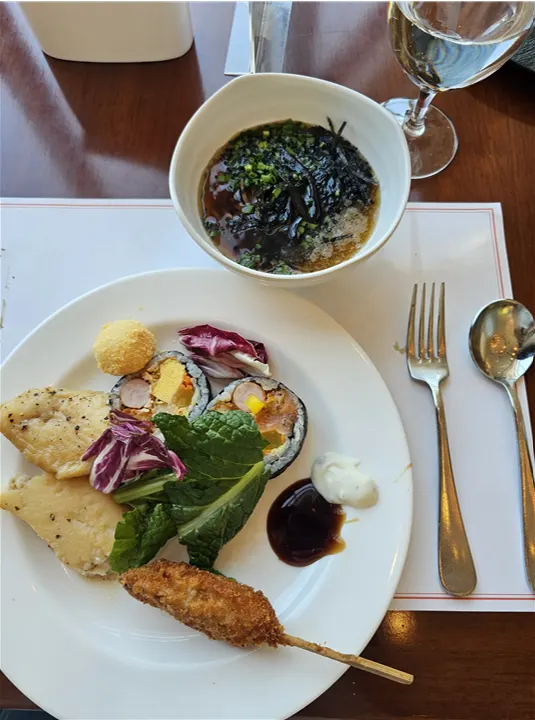 A plate with abalone, shrimp, and fried items