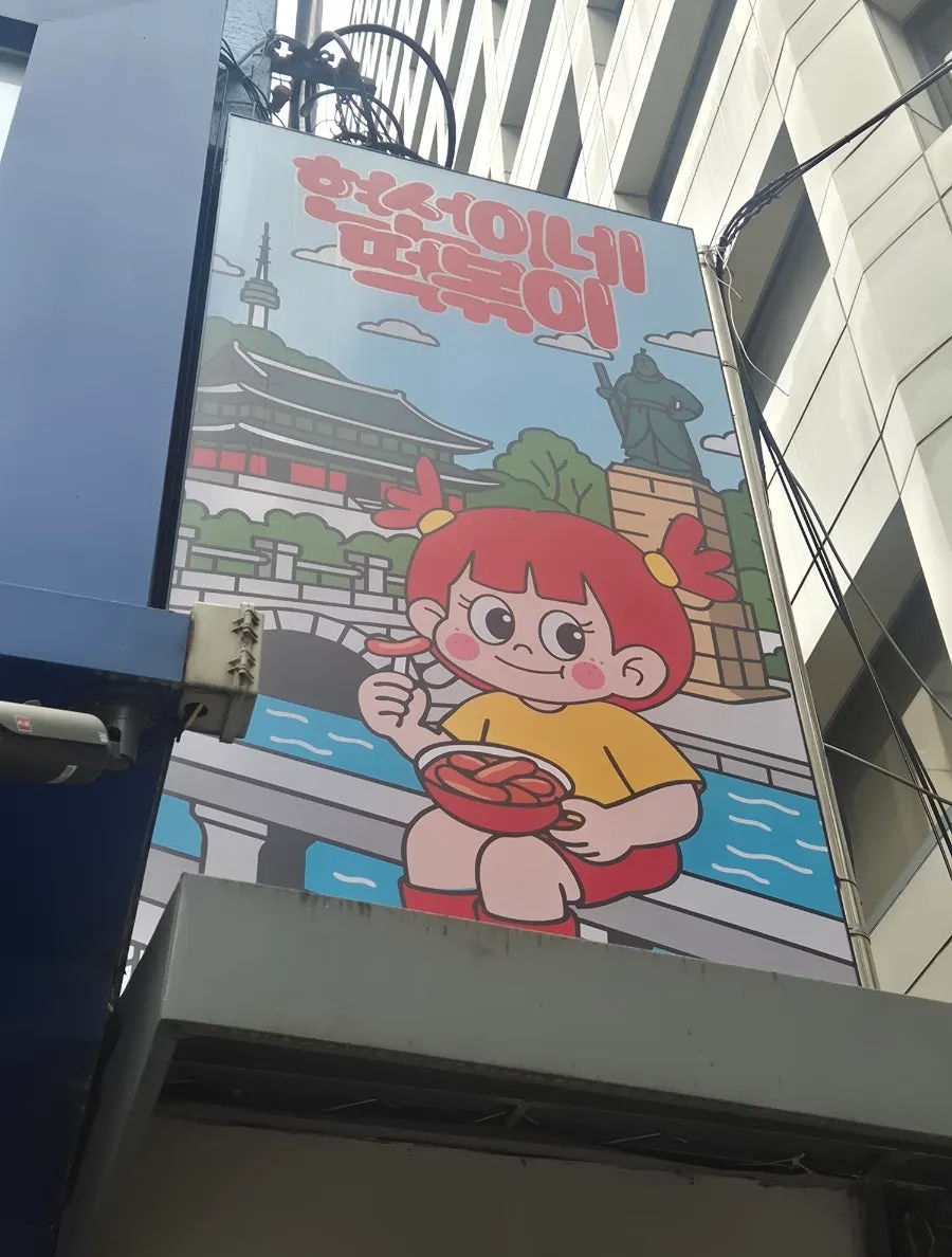 Store sign with the Hyeonseoni character eating tteokbokki