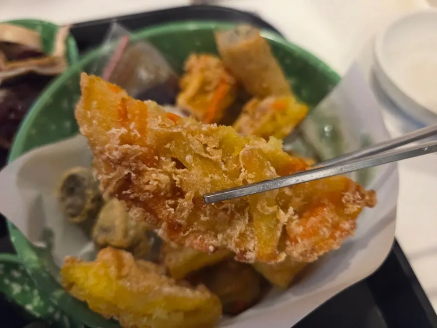 Plate of assorted fried snacks with squid, kimmari, vegetable, meat mandu, and sweet potato