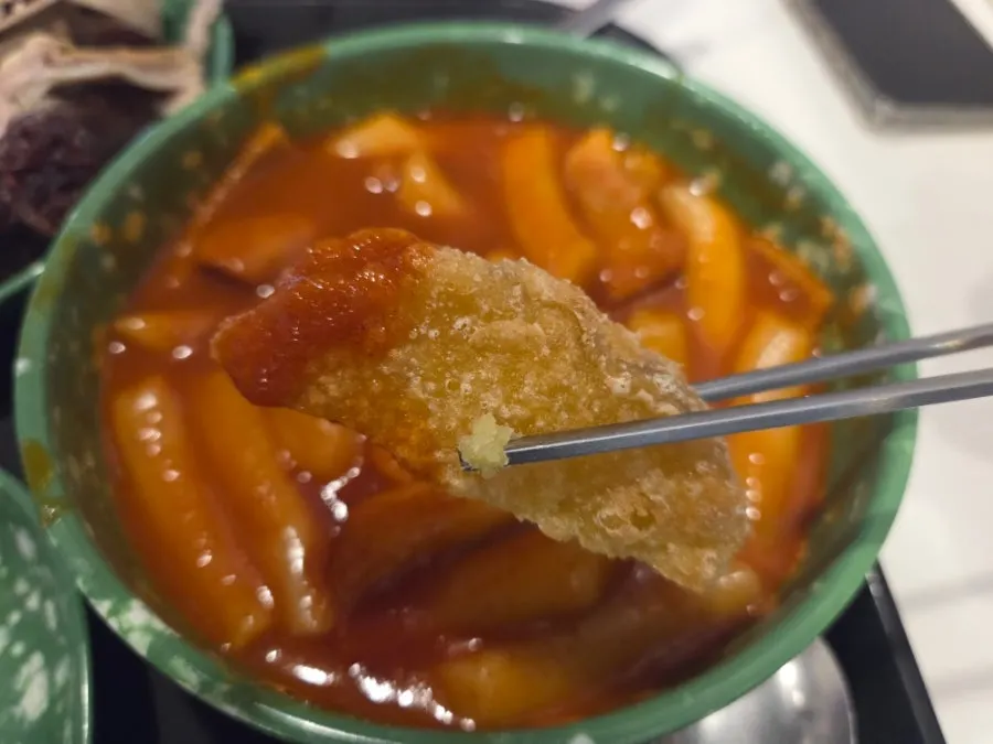 Fried snack dipped in tteokbokki broth