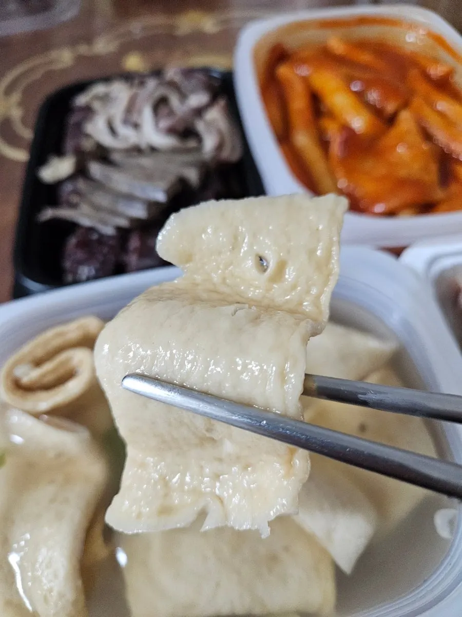 Close-up of rice cake coated in tteokbokki sauce