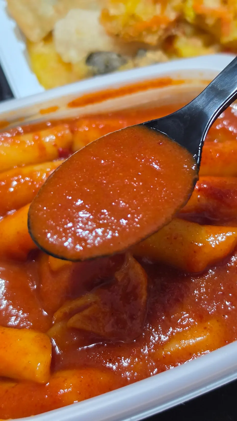 Picking up a piece of tteokbokki rice cake