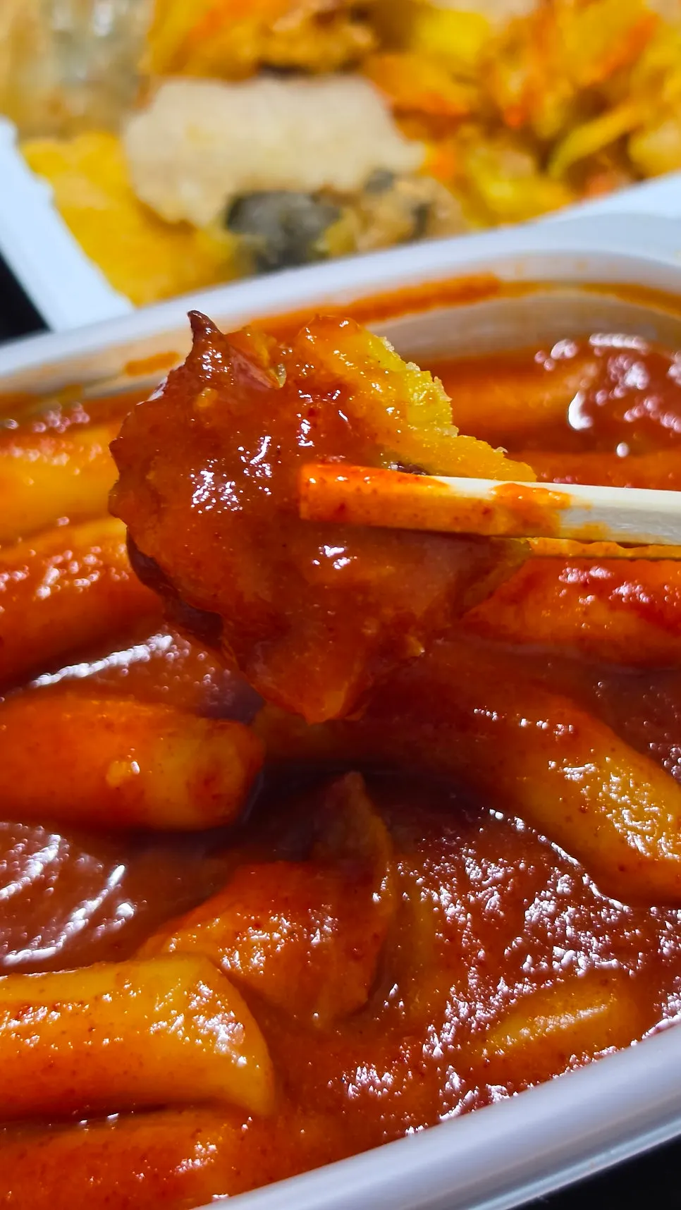 Fried snack dipped in tteokbokki sauce