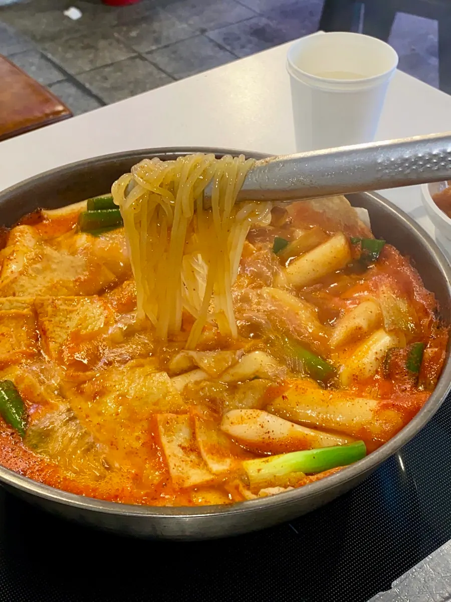 The included jjolmyeon noodle topping being lifted out