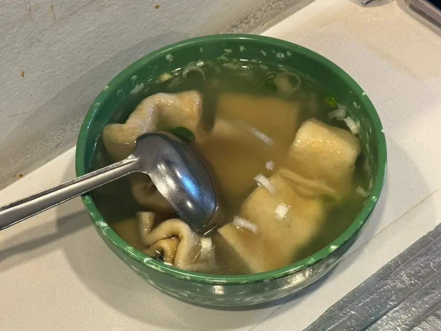 Fish cake broth served in a green bowl