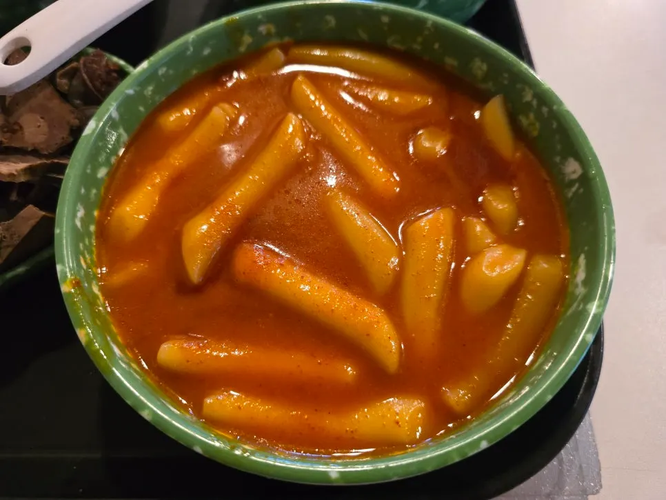 Broth tteokbokki in a green bowl