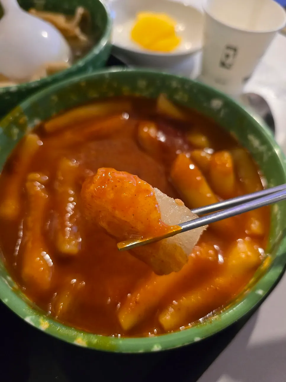 Hand picking up seasoned tteokbokki