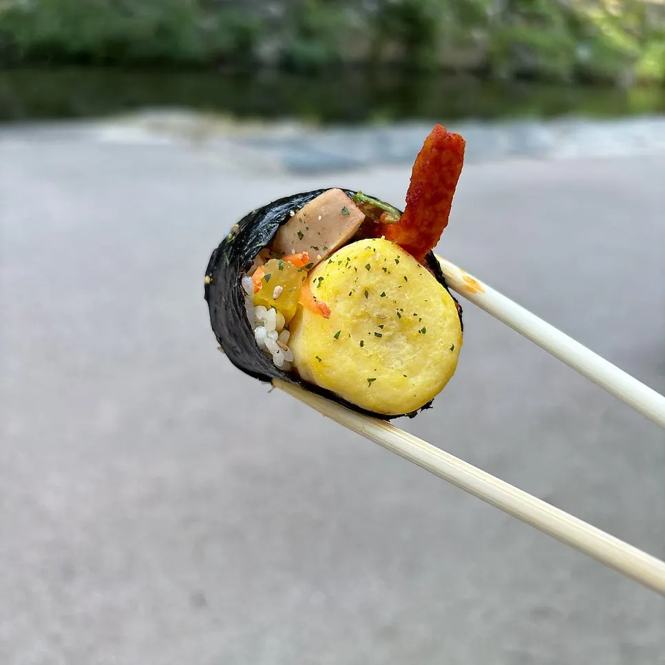 Cross-section of vegetable whole-egg gimbap with Spam and burdock root