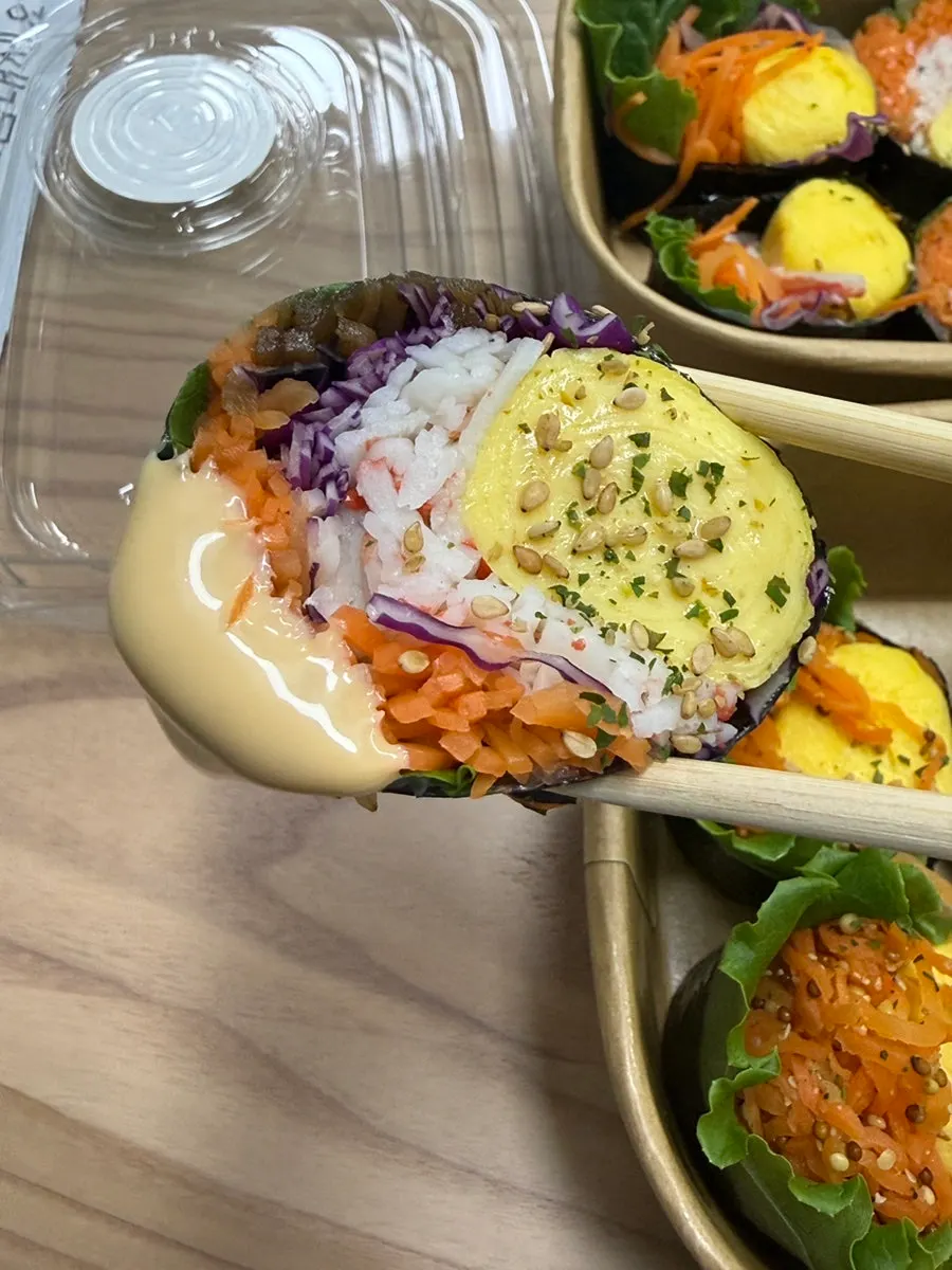 Cross-section of crab-stick keto gimbap dipped in sauce