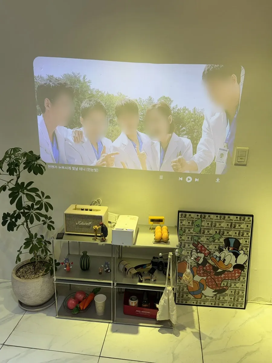 Corner of the store with a video playing on the wall and decorative props