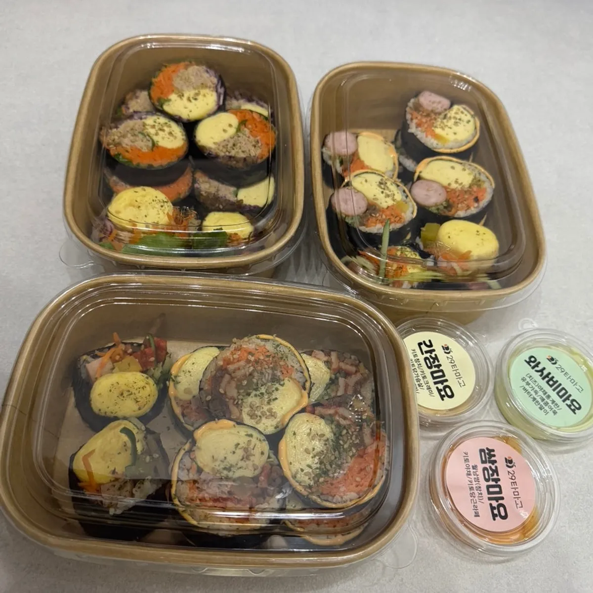 Three rolls of keto gimbap and three sauces laid out at home