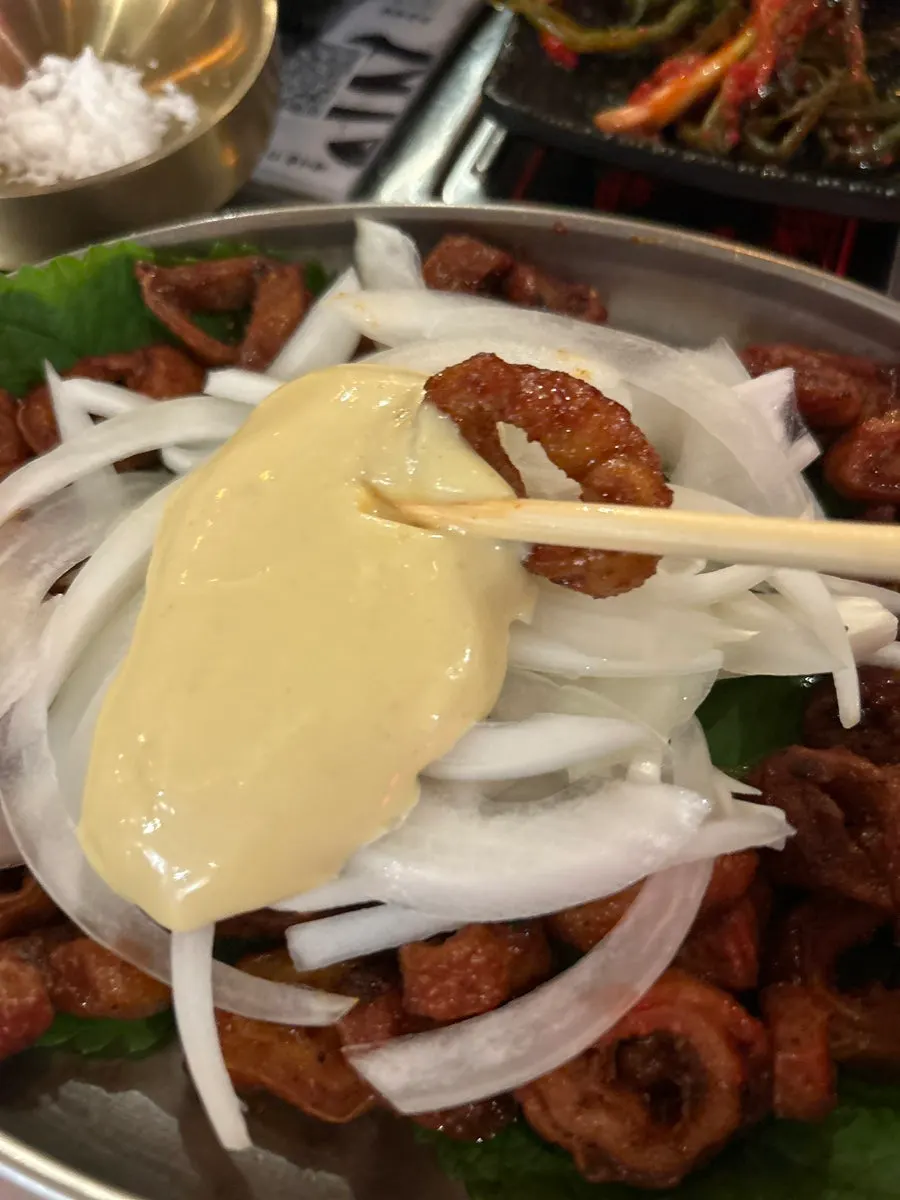 Spicy grilled makchang served with onion and cheese sauce