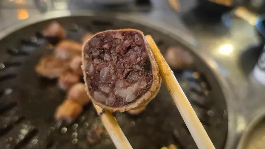 Makchang eaten in a perilla-leaf wrap