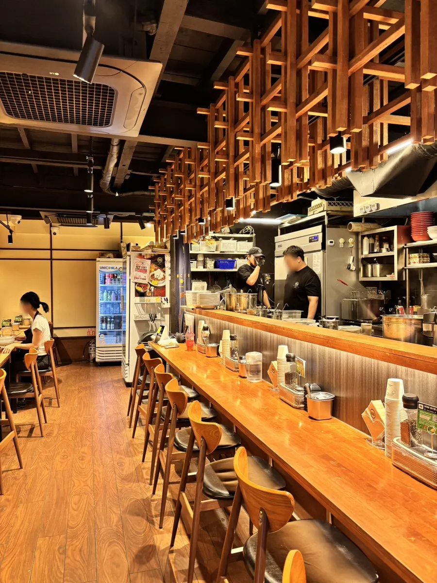 Restaurant interior with counter seats and tables for two