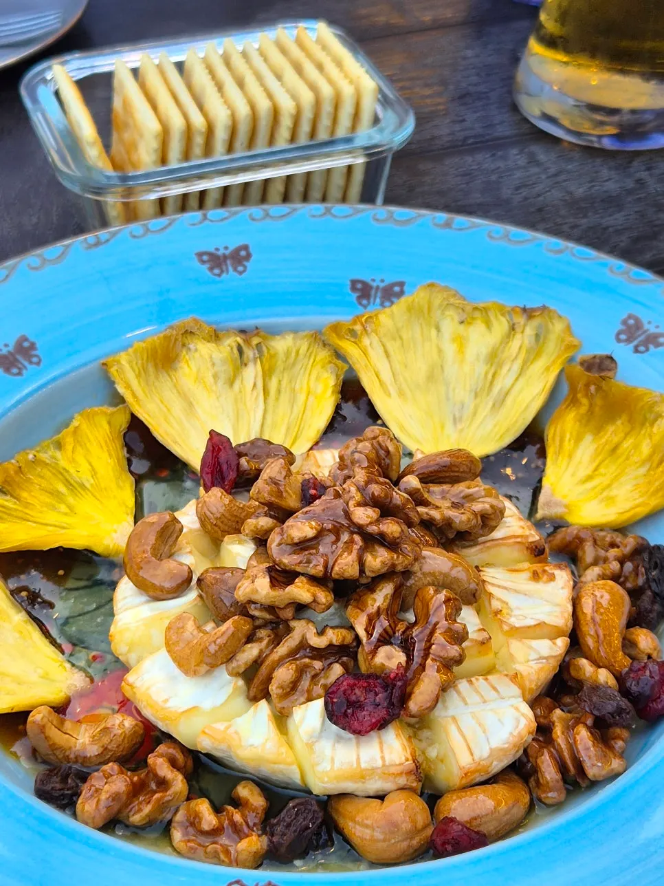 A plate of grilled brie topped with nuts