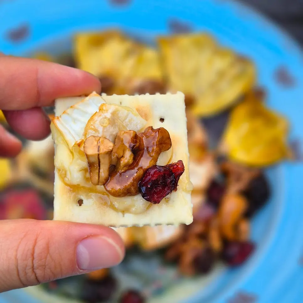 Brie and nuts piled onto a cracker