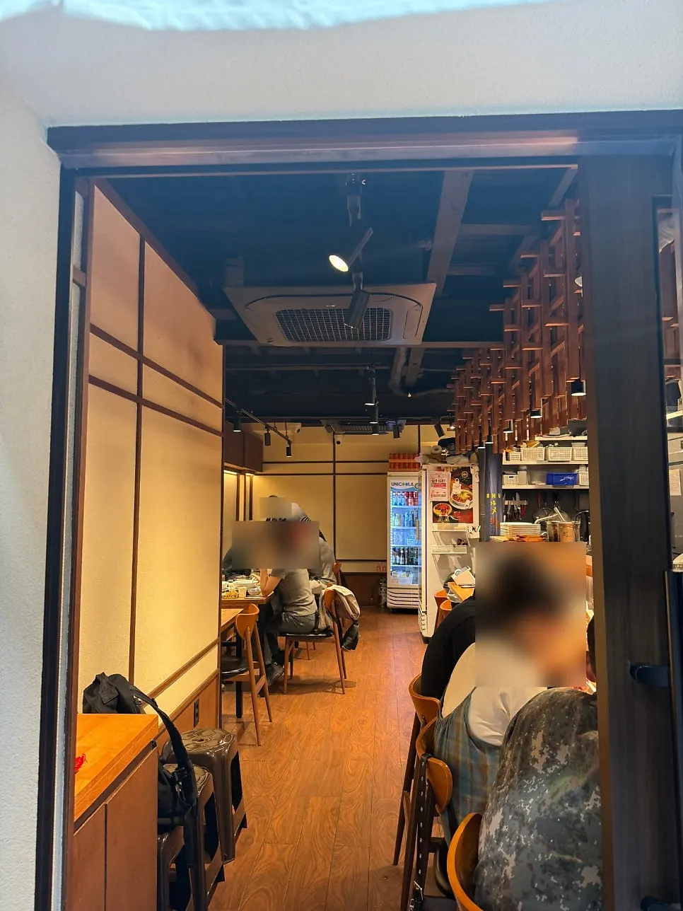 원목 가구와 간접 조명이 있는 멘츠루 실내
