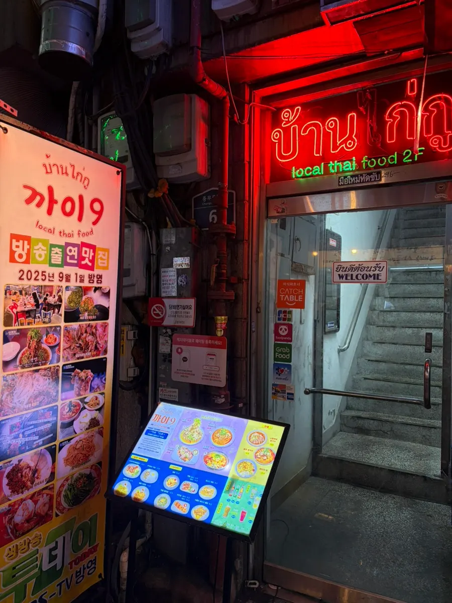 Kkai 9's exterior lit up with neon signs