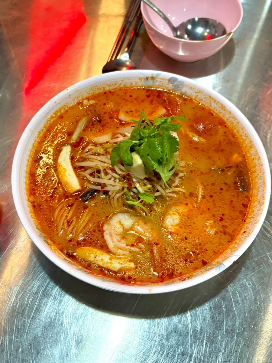Close-up of tom yum rice noodles topped with cilantro