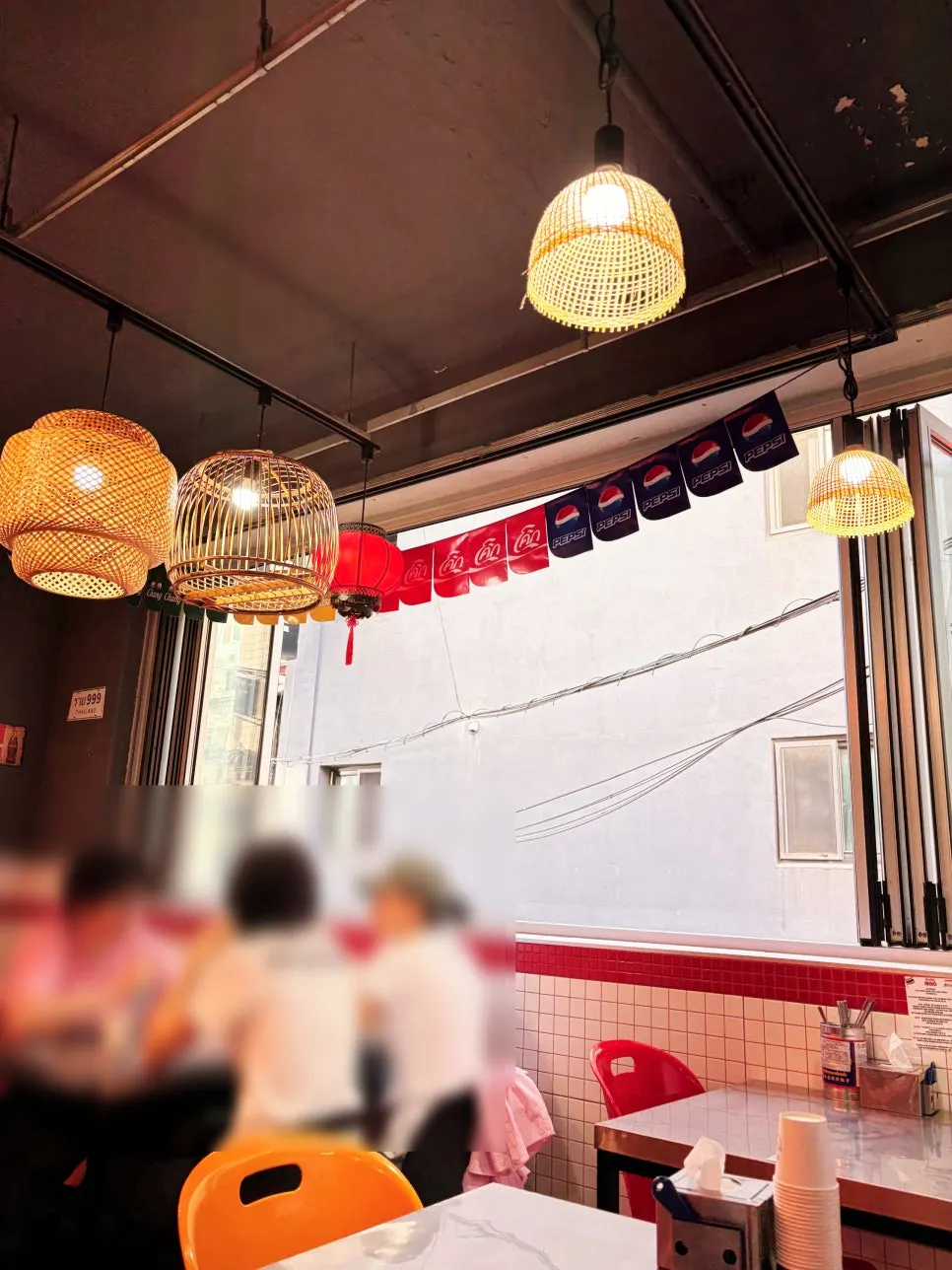 Bar seating by open windows and steel tables